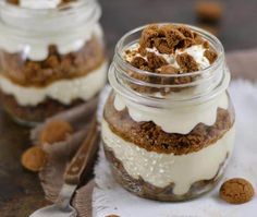 two jars filled with dessert sitting on top of a table