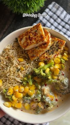 a white bowl filled with rice, broccoli and chicken on top of it