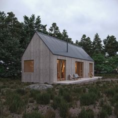 a small wooden house sitting on top of a grass covered field next to trees and bushes