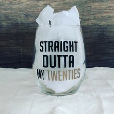 a wine glass with the words straight outa my twenties printed on it and tissue paper