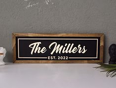 a wooden sign that says the millers est, 202 on it next to a plant