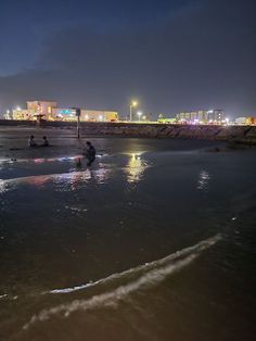 people are sitting on the beach at night