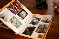 an open book with pictures on it sitting on a wooden table next to a camera