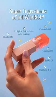 a hand holding an orange lip bale in front of a blue background with the words super ingredients of dewdrop