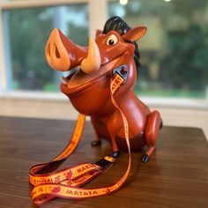 a toy horse with a leash attached to it's neck sitting on a table