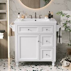 a bathroom with a sink, mirror and towels on the rack in front of it