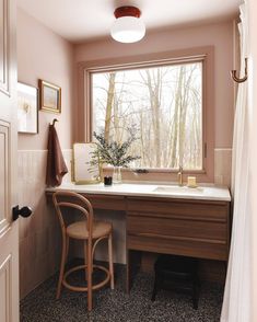 a bathroom with a sink, mirror and stool next to a window in the corner