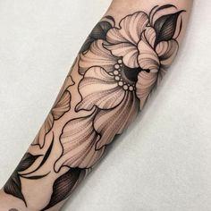 a black and white flower tattoo on the arm