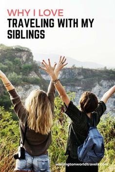 two women with their arms in the air above them are looking at mountains and trees