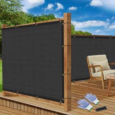 a chair and table on a deck with a black privacy panel over it's top