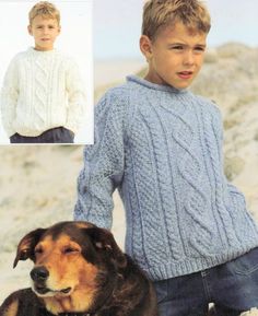 a boy and his dog wearing sweaters on the beach