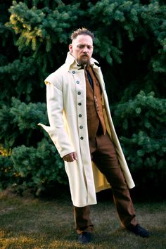 "Each year we make some of the most unique overcoats in the world. This particular piece was designed as the finale for one of our fashion shows where we had selected a vintage military vibe. The style borrows not only from the details----but also from the techniques and materials---of the 18th century. The style is cut from heavyweight 25oz wool melton with a raw edge finish to create sharp edges. The lapels and cape edges (as on most 18th century military pieces) are finished with a line of to Steampunk Outerwear With Stand Collar For Winter, Steampunk Winter Outerwear With Stand Collar, Winter Steampunk Outerwear With Stand Collar, Cosplay Long Coat With Buttons, Winter Costume Double-breasted Outerwear, Winter Cosplay Outerwear With Button Closure, Fall Cosplay Outerwear With Button Closure, Historical Long Coat For Fall, Steampunk Long Coat With Buttons