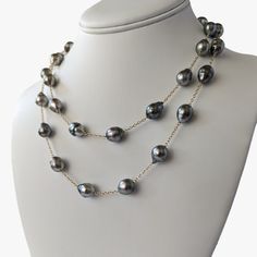 Introducing our exquisite Tahitian Pearl Station Long Necklace, a testament to refined elegance in modern jewelry design. This piece artfully marries the timeless allure of pearls with the luxurious warmth of 14K yellow gold, creating an accessory of modern sophistication. The necklace is 36 inches in length and weighing 46.5 grams, is crafted with meticulous attention to detail. It can be worn long for a more dramatic look, or wrapped double. It features semi-baroque and circled drops Tahitian Elegant Yellow Gold Tahitian Pearl Jewelry, Formal Tahitian Pearl Necklace In Yellow Gold, Formal Yellow Gold Tahitian Pearl Necklace, Luxury Tahitian Pearl Necklace For Formal Occasions, Elegant Single Strand Tahitian Pearl Necklace, Luxury Single Strand Tahitian Pearl Necklace, Luxury Tahitian Pearl Single Strand Necklace, Luxury Tahitian Pearl Necklace, Elegant Tahitian Pearl Jewelry With Round Beads