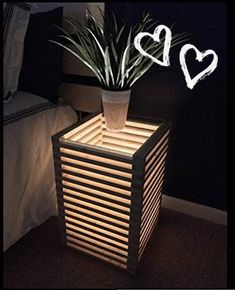 a potted plant sitting on top of a wooden box next to a bed in a room