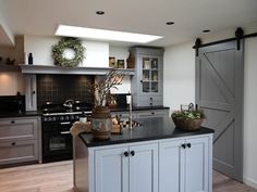 a kitchen with gray cabinets and black counter tops