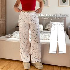 a woman standing in front of a bed wearing white pants and a red tank top