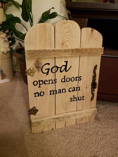 a wooden sign that says god opens doors and no man can shut it on the floor