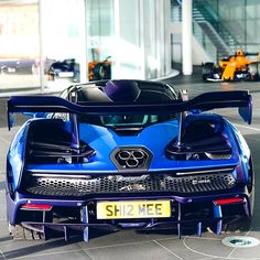 a blue sports car parked in front of a building