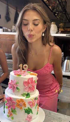 a woman blowing out the candles on her birthday cake