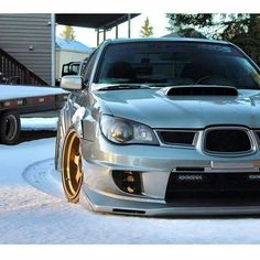 a silver car is parked in the snow