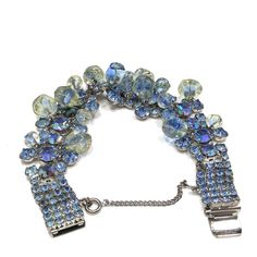 "*Description: This is a beautiful wide blue rhinestone bracelet with aurora borealis accent rhinestones from the 1950s. The unique design has clear glass beads dangling throughout most of the bracelet. The beads look like free form, yet are all uniform in design. They have a slight yellow tint which matches one of the colors in the aurora borealis blue rhinestones. The bracelet has a push box clasp with three rhinestones on top of the clasp. This bracelet would be beautiful for a wedding, \"som Vintage Jeweled Crystal Bracelets, Vintage Crystal Bracelet For Party, Vintage Blue Bracelets For Party, Blue Costume Jewelry Bracelet, Adjustable Blue Crystal Bracelet With Rhinestones, Blue Crystal Bracelet With Rhinestones, Luxury Vintage Blue Bracelets, Vintage Blue Rhinestone Jewelry, 1950s Bracelet