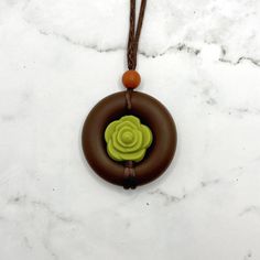 Squish Level: 8 Durability Level: 10 A fidget necklace meant to look like a succulent surrounded in dirt.  The cord has sliding knots so the length is adjustable. The longest length it can be adjusted to is about 32 inches, meaning it can hang down about 16 inches. You can twist the middle bead to fidget, or squish or chew on the pendent.  The entire pendent is made of a soft, smooth, food-grade silicone.  My fidget jewelry is for adults. Clean often with soap and warm water. Discard if the sili Nature-inspired Adjustable Necklace For Everyday, Brown Necklace With Sliding Knot For Gift, Casual Adjustable Necklace With Round Pendant, Casual Adjustable Round Pendant Necklace, Everyday Brown Necklace With Adjustable Length, Brown Adjustable Length Necklace For Everyday, Adjustable Sliding Knot Necklace With Round Pendant, Adjustable Earthy Necklace For Everyday Wear, Adjustable Round Pendant Necklace With Sliding Knot