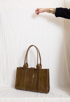 The most beautiful bag we have ever made. 10” x 16” with a 5” gusset. 10” strap fall. Large zippered pocket inside. Slip pocket on the back Solid brass feet. Leather lined bottom. Snaps on each side to help retain the polished shape + to keep your goods extra safe. When exposed to sunlight, oils and water, Veg Tan leather will grow darker over time and develop a lovely dark patina. This patina is natural and is what gives this type of leather its coveted color. At this time, please allow 3 weeks Veg Tan Leather, Wallet Accessories, Womens Tote, Beautiful Bags, Tan Leather, 3 Weeks, Inside Pocket, Solid Brass, Satchel