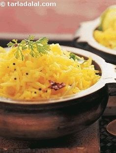 two bowls filled with yellow rice and garnished with parsley on the side