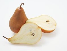 an apple and pear cut in half on a white background