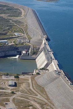 an aerial view of a large body of water with a dam in the middle and buildings on both sides