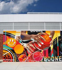 a large mural on the side of a building that has basketballs painted on it