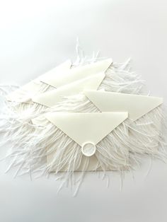 several pieces of paper with white feathers on them