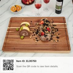 a wooden cutting board topped with fruit and nuts next to wine glasses on a marble counter top