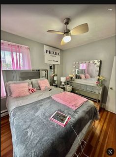 a bed room with a neatly made bed and a ceiling fan