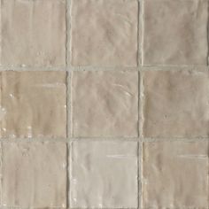 a white tile floor with several different shades of beige and tan tiles on it's sides