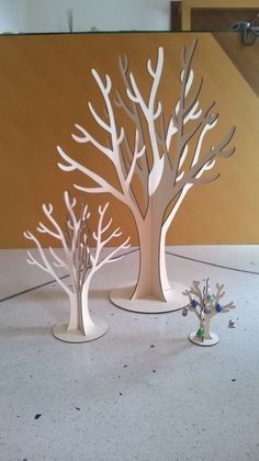 three paper cut trees sitting on top of a table