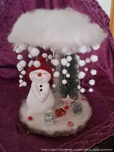 a snowman is standing under a white cloud with christmas decorations on the top and below it