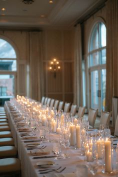 a long table is set with candles and place settings