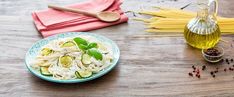 pasta with cucumbers and herbs on a wooden table