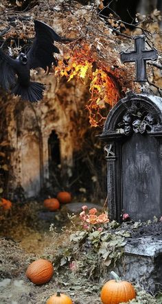 a cemetery with pumpkins and bats in the foreground