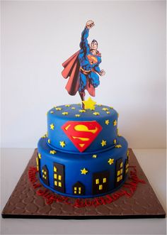 a birthday cake with a superman figure on top