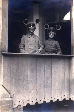 two men in uniforms are standing at the window