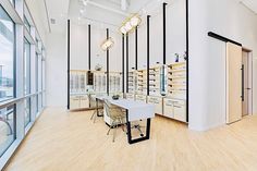 a large room with lots of windows and white furniture in the center is an eyeglass store