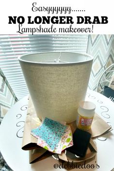 a lamp shade sitting on top of a table next to some fabric and glues