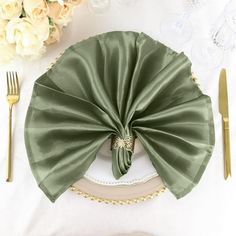 a place setting with napkins, silverware and flowers