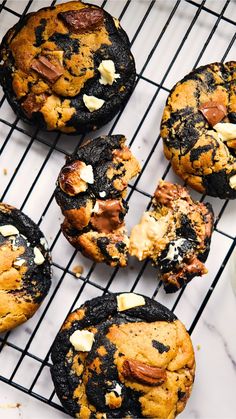 chocolate chip cookies cooling on a rack with butter and other toppings next to a glass of milk