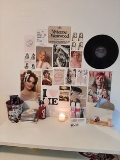 a white table topped with pictures and candles next to a wall covered in magnets