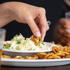 a person is dipping some food on a plate