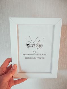 two hands holding each other in a white frame