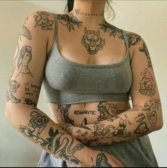 a woman with lots of tattoos on her arm and chest is posing for the camera